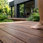 Terrasse bois en ipe aux lames cannelées bordant un jardin, teinte brun olive
