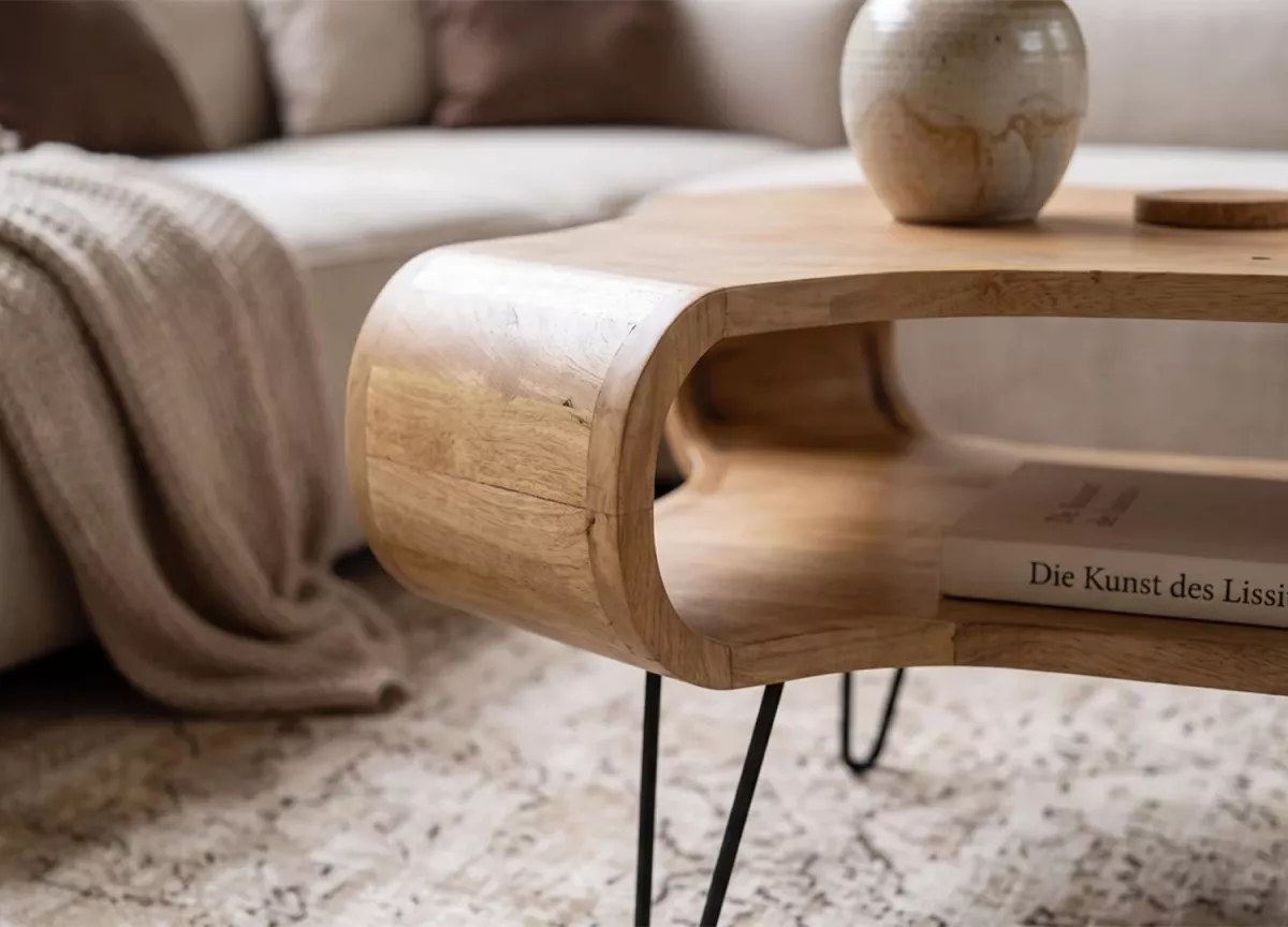 Table basse en manguier massif avec plateau en bois et piètement en métal noir dans un salon