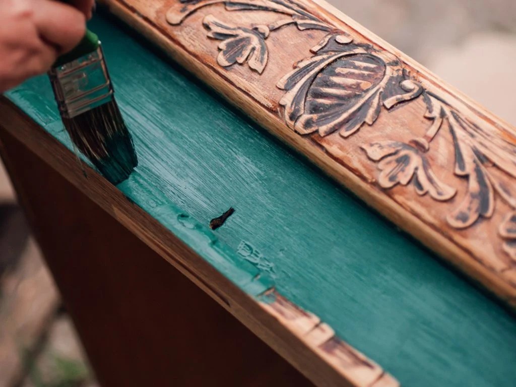 Meuble en bois ancien repeint dans une teinte vert sauge dans un intérieur lumineux