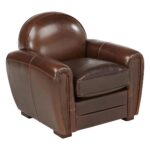 Fauteuil vintage en cuir marron patiné au dossier enveloppant dans un salon chaleureux