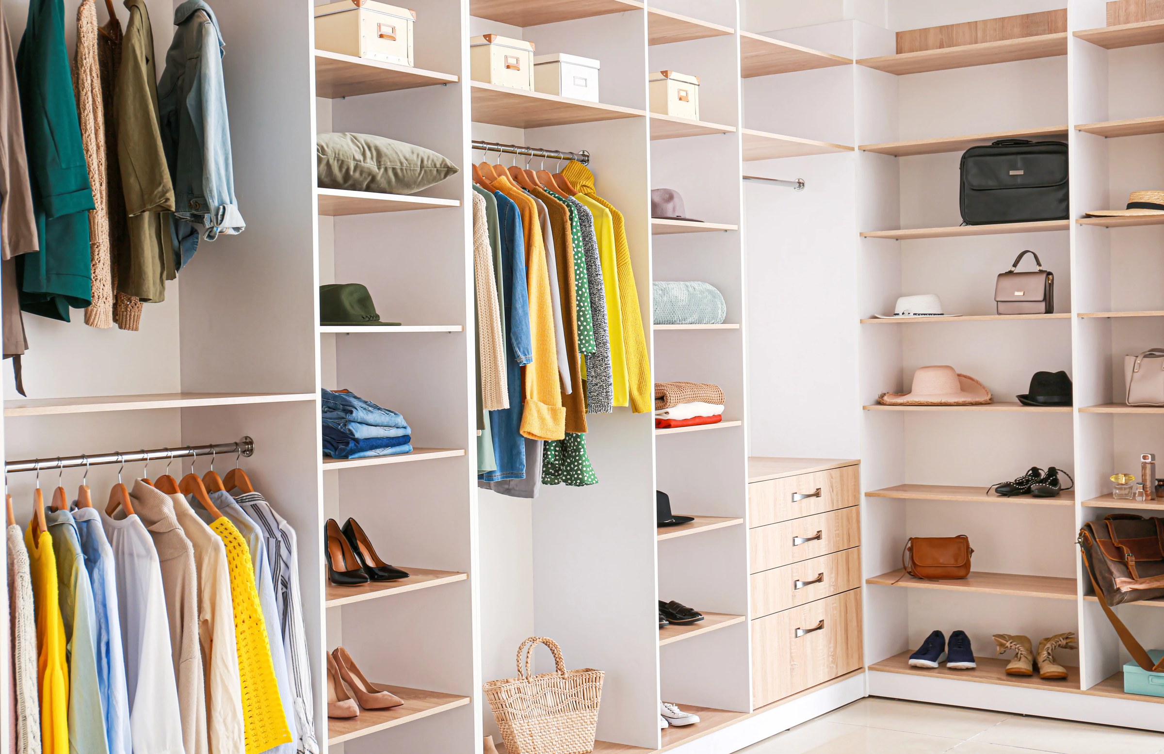 Dressing en bois intégré le long d'un mur de chambre avec penderie, tiroirs et étagères ouvertes